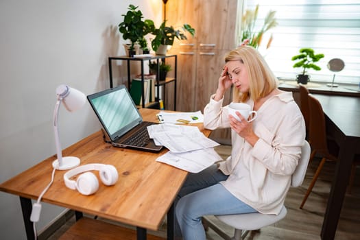 Feeling overwhelmed with work tasks while sipping coffee at a desk