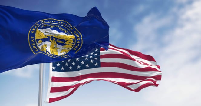 Nebraska state flag waving with the American flag in background on a clear day. Dark blue with a large state seal of Nebraska at its center. 3d illustration render. Rippling fabric. US state flag