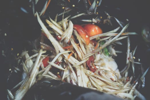 Papaya salad or Papaya Pok Pok (Som tum) for sale at Thai street food market or restaurant in Thailand