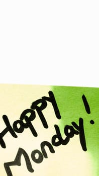 Happy Monday handwriting text close up isolated on green paper with copy space. Writing text on memo post reminder