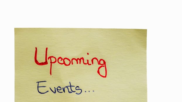 Upcoming events handwriting text close up isolated on yellow paper with copy space.