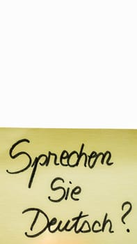 Sprechen sie deutsch ( do you speak german) handwriting text close up isolated on yellow paper with copy space.