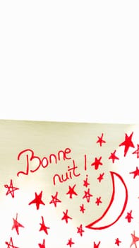 Bonne nuit (good night) handwriting text close up isolated on yellow paper with copy space.