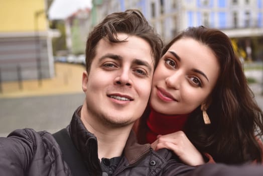 A beautiful young couple takes a selfie on the street. A couple in love take a selfie together.