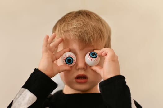 A boy fooling around with capillary eyes on Halloween