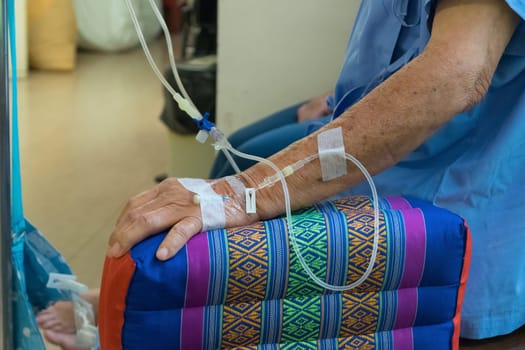 A patient in the hospital with saline intravenous, in Asian elderly man hand