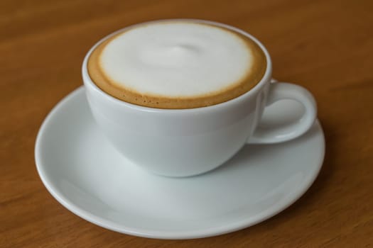 Coffee in white cup on wood table