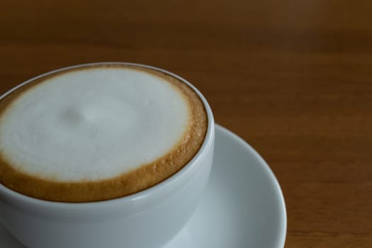 Coffee in white cup on wood table