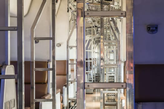 Inside of old public Thai railway train cabin with seats, handrails, fan and interior in vintage style service for passenger transport
