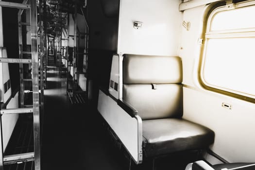 Inside of old public Thai railway train cabin with seats, handrails, fan and interior in vintage style service for passenger transport