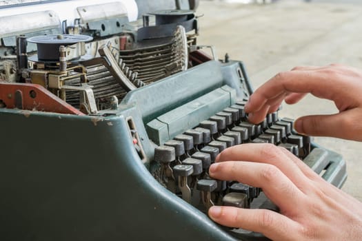 Vintage typewriter and human hand on a wood table