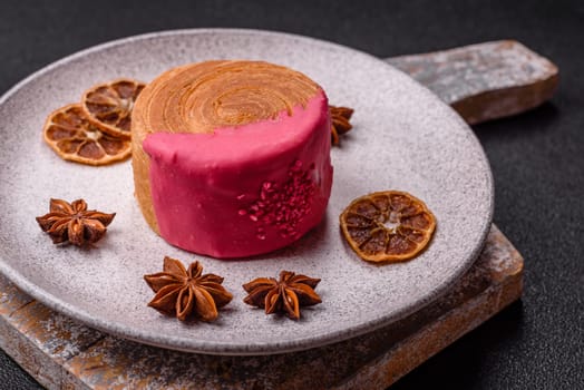 Round sweet New York roll croissant with raspberry cream filling on a dark concrete background
