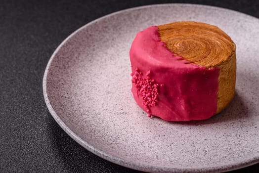 Round sweet New York roll croissant with raspberry cream filling on a dark concrete background