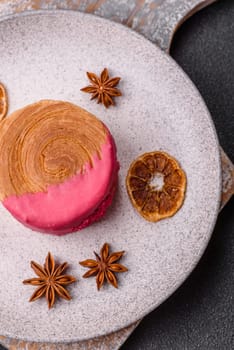Round sweet New York roll croissant with raspberry cream filling on a dark concrete background
