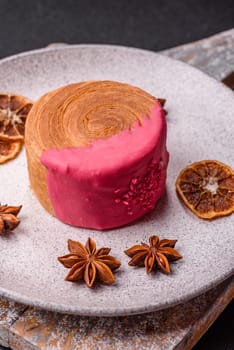 Round sweet New York roll croissant with raspberry cream filling on a dark concrete background