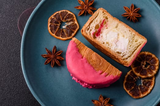 Round sweet New York roll croissant with raspberry cream filling on a dark concrete background