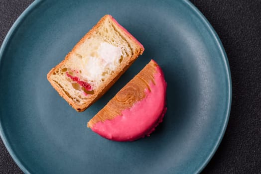 Round sweet New York roll croissant with raspberry cream filling on a dark concrete background