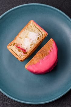 Round sweet New York roll croissant with raspberry cream filling on a dark concrete background