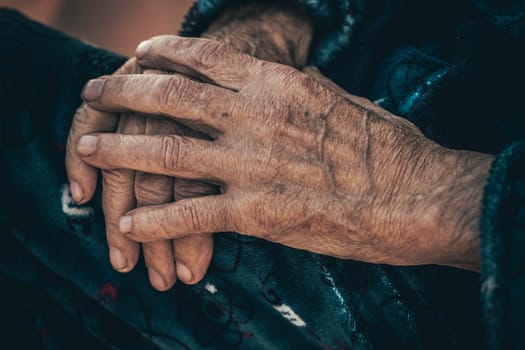 closeup of a hand of an old man resting on a soft surface, showcasing the texture of the skin and the contrast between age and comfort.
