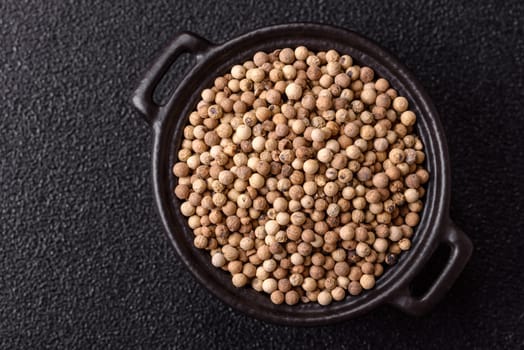White allspice in a ceramic bowl on a dark concrete background