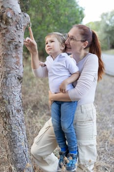 A woman and a child are looking at a tree. Scene is warm and loving
