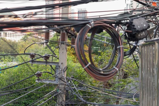 Electricity system with tangled cable of power line and electric wire on a road in a city
