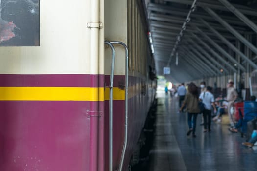 Railway train on the railroad tracks in Bangkok station. Many people in Thailand popular travel by train because it is cheaper.