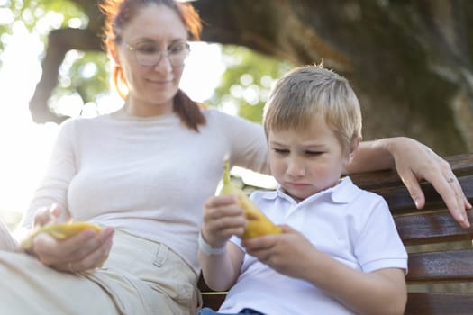 Young boy looking sad while holding a banana and having a difficult conversation with his mother