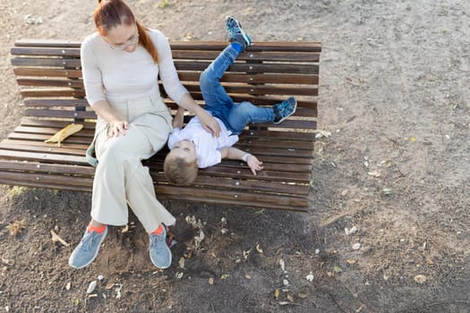 Mother and son relaxing on bench and enjoying time together