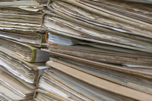 Old files in old folder stacking up in a messy order.