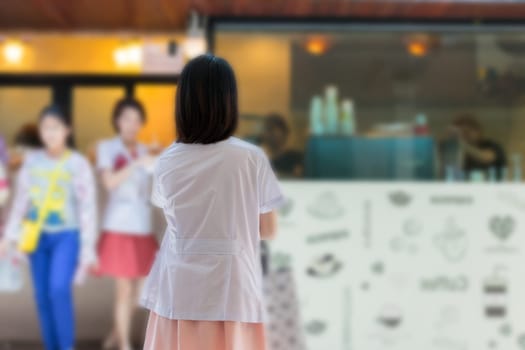 Asian women in white gown about health care professional standing for waiting a coffee at coffee shop in hospital.
