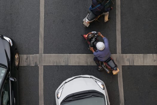 Car and Motorcycle wait to go at intersection with traffic light on a road.