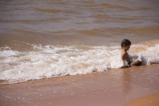 Asia boy travel playing at LaemMaePhim beach. This white sandy cape can be easily reached from city.