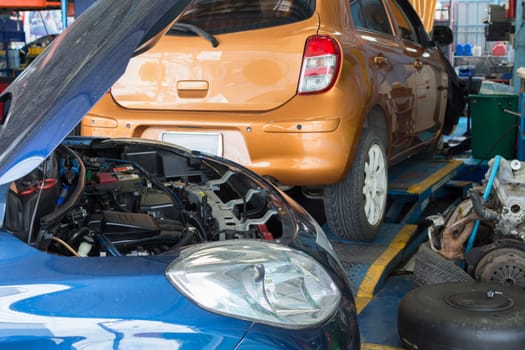 Serviceman checking a car for fix and repair at garage