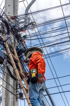 Worker working to install electric line by scaffolding on pickup truck at Bangkok Thailand.