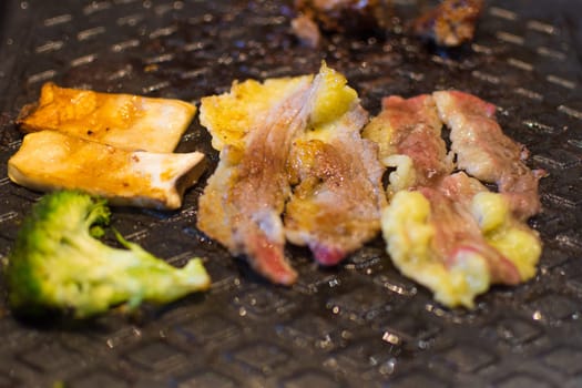 Grilled raw meat (barbeque,bbq) cooking on wagyu grill in BBQ. yakiniku grill buffet restaurant