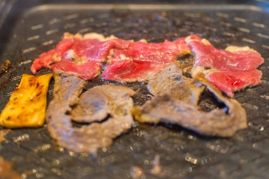 Grilled raw meat (barbeque,bbq) cooking on wagyu grill in BBQ. yakiniku grill buffet restaurant