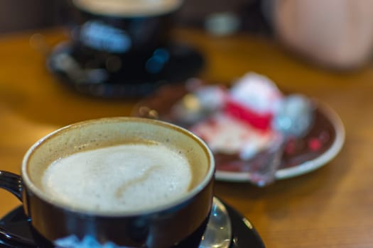 Hot Coffee in black cup on wood table