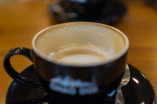 Hot Coffee in black cup on wood table