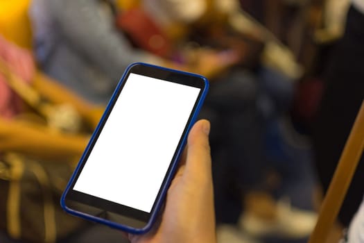 Person hand holding smartphone or mobile phone with white screen using in skytrain for checking