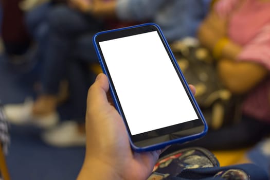 Person hand holding smartphone or mobile phone with white screen using in skytrain for checking