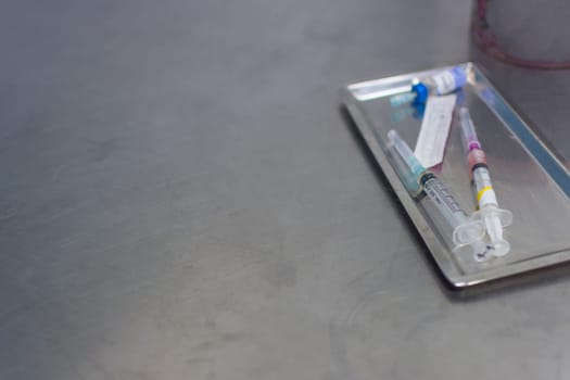 Syringe with needle on a steel tray for a medical vaccine in a hospital