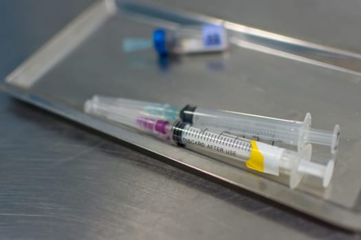 Syringe with needle on a steel tray for a medical vaccine in a hospital