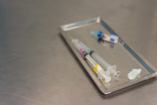 Syringe with needle on a steel tray for a medical vaccine in a hospital