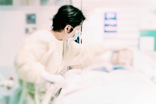 Asian women 40s years old in gown coat is a patient relative taking care of the CRE. or VRE. infected elder patient 80s years old on bed in the hospital.