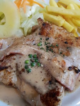Meat steak (Beef or Pork steak) with mashed potatoes in white dish for sale at Thai street food market or restaurant in Bangkok Thailand