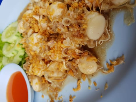 Garlic fried scallop ligament pen shell for sale at Thai street food market or restaurant in Thailand