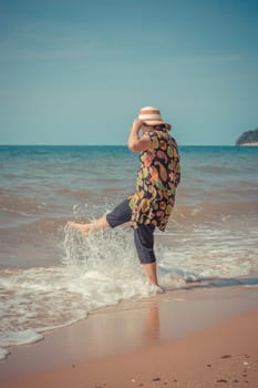 Asia woman plump body in colorful dress with hat posing at beach with blue sea and sky when travel , process in vintage style