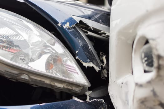 Car crash from car accident on the road in a city between saloon versus pickup wait insurance.