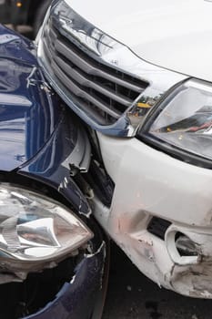 Car crash from car accident on the road in a city between saloon versus pickup wait insurance.